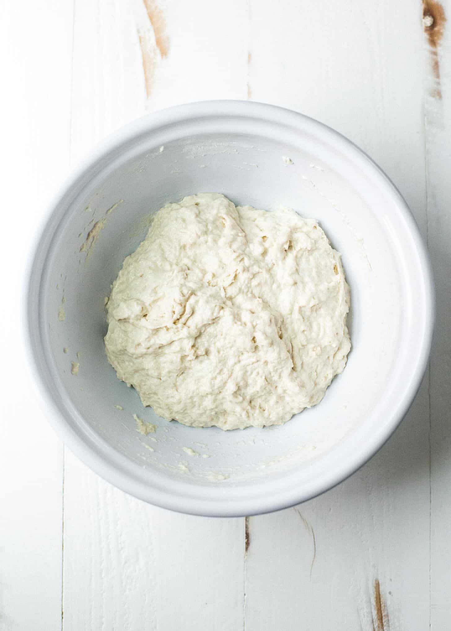 overhead image mixed No knead sandwich bread dough in a white bowl