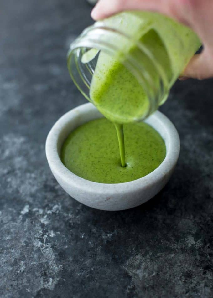 pouring cilantro lime vinaigrette into a small bowl