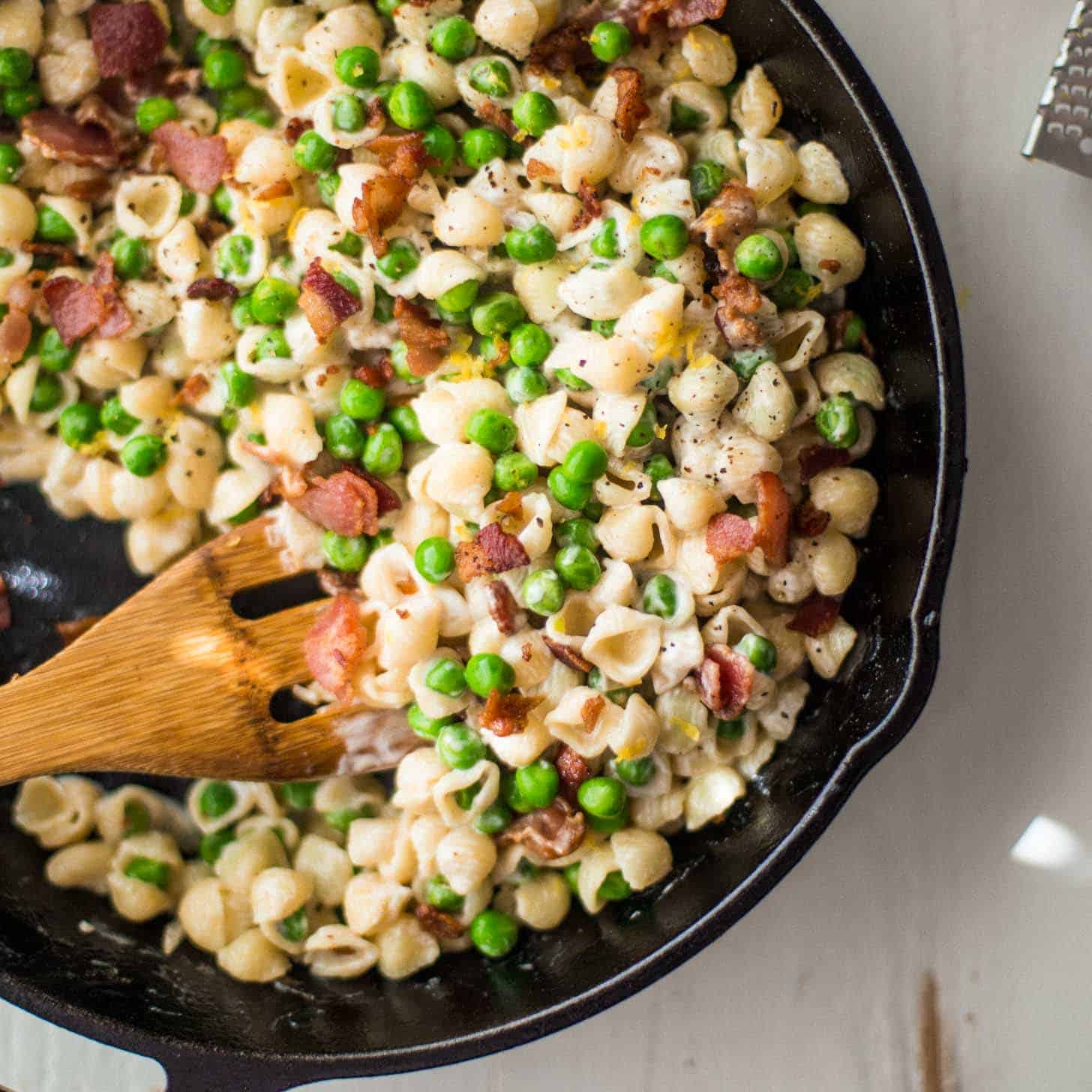Creamy Shells with Peas and Bacon in a cast iron skillet