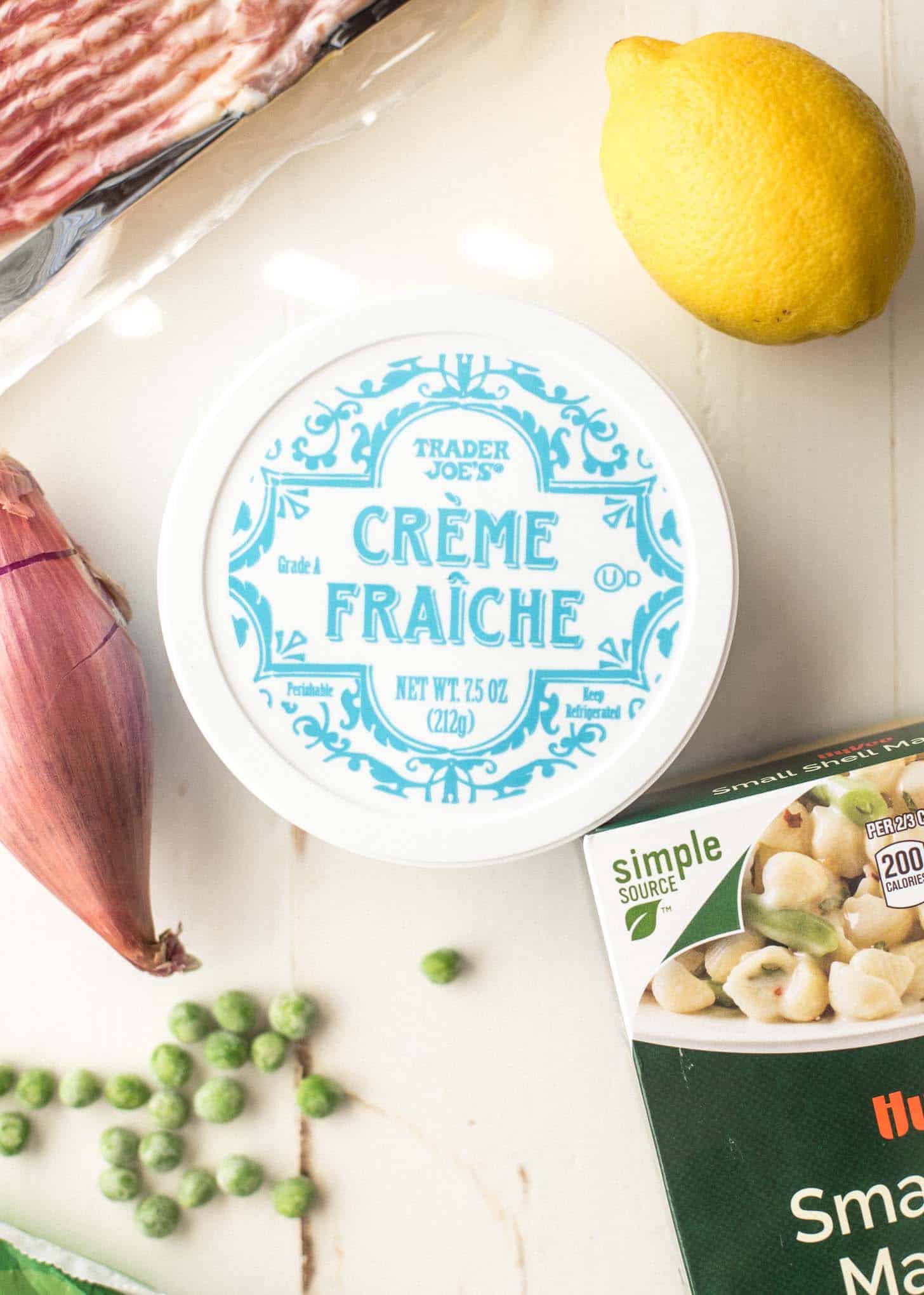 overhead image of creme fraiche on a table with a lemon and shallot