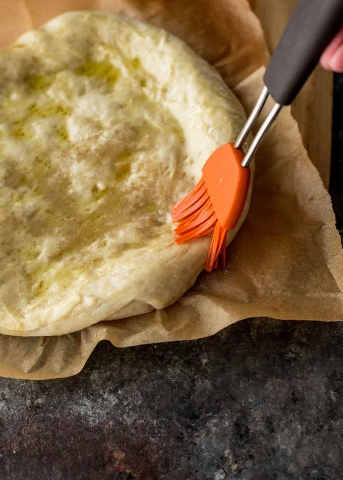 brushing pastry dough with olive oil