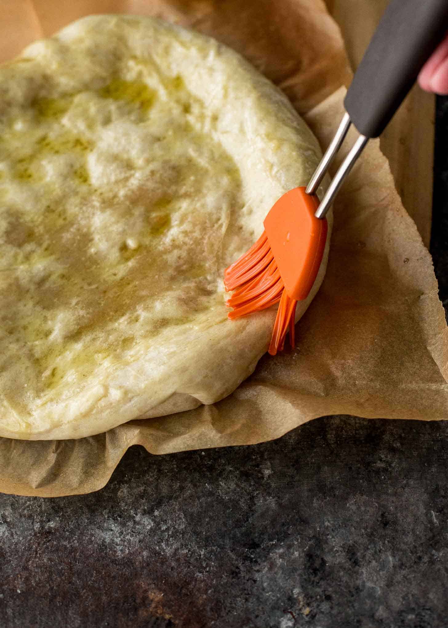 brushing pastry dough with olive oil