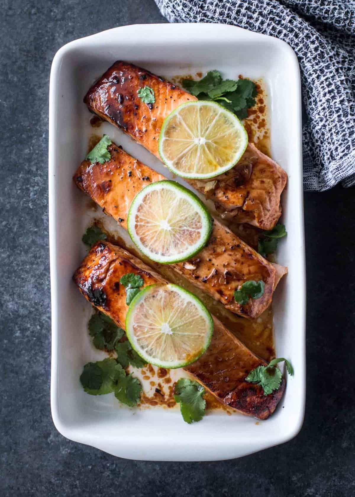 lime topped broiled salmon in a white baking dish