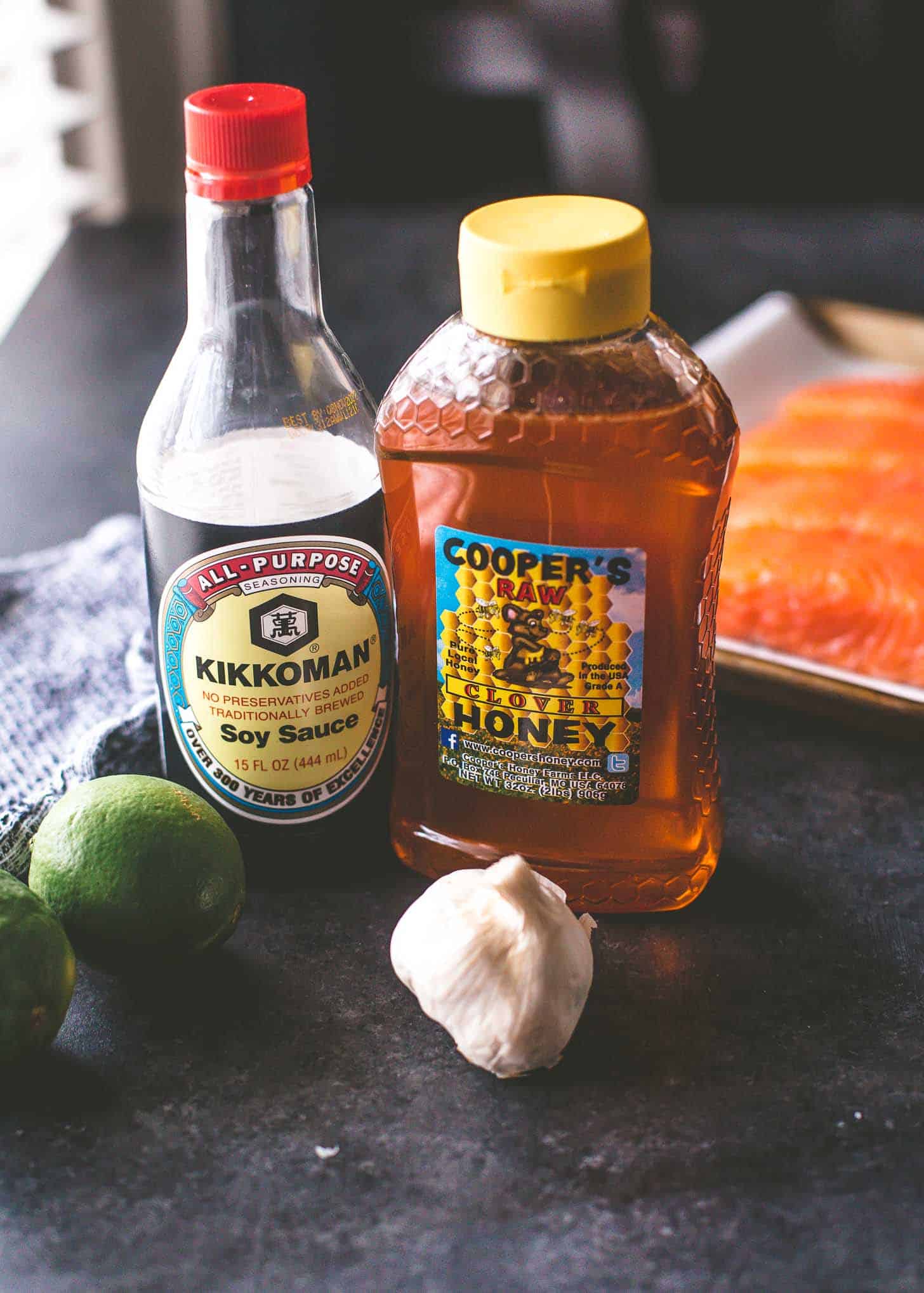 honey, soy sauce, garlic and lime on a grey table