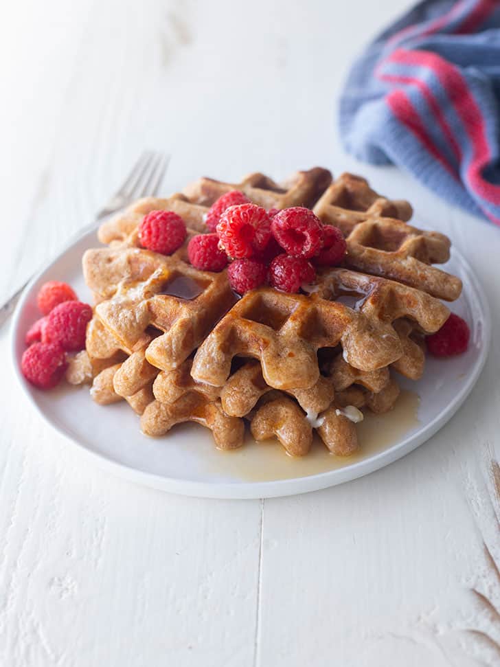 waffles on a white plate with raspberries