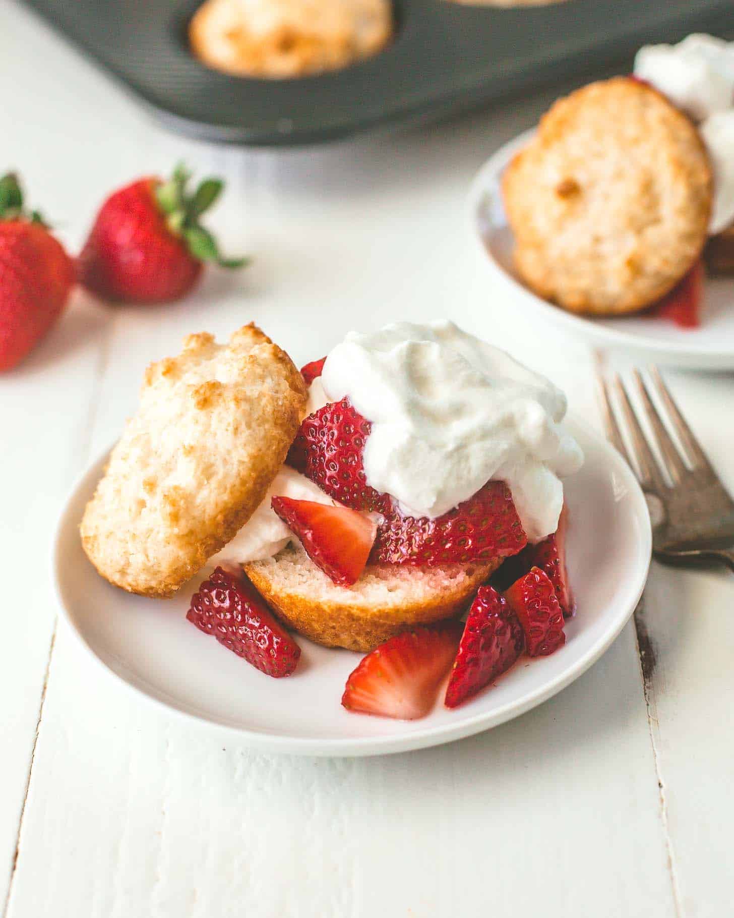 Muffin Pan Strawberry Shortcake topped with whipped cream on a white table