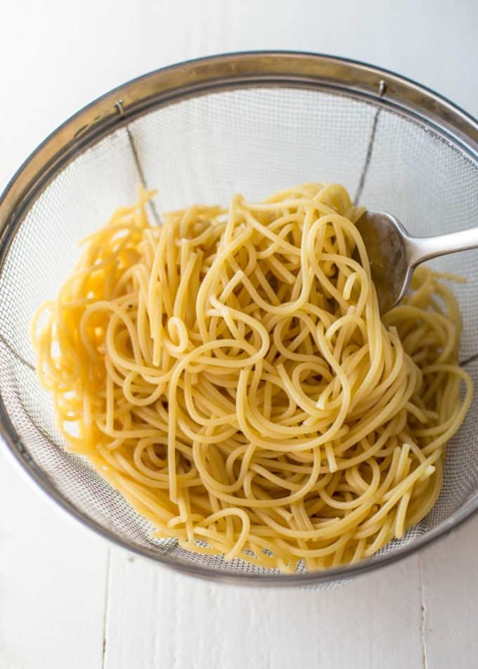 Spaghetti in a Colander on a white table