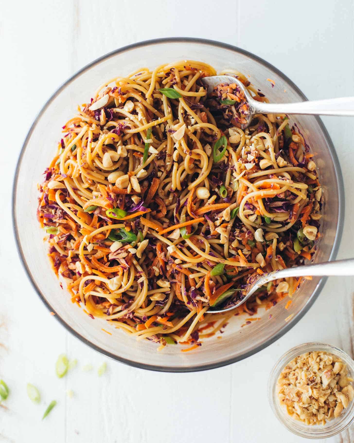 Sesame Noodle Salad in a clear bowl with 2 large spoons