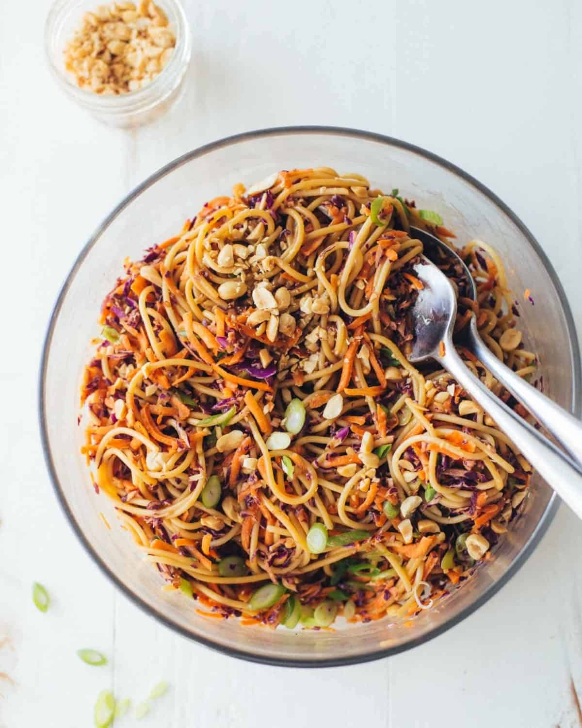Sesame Noodle Salad in a clear bowl with 2 large spoons