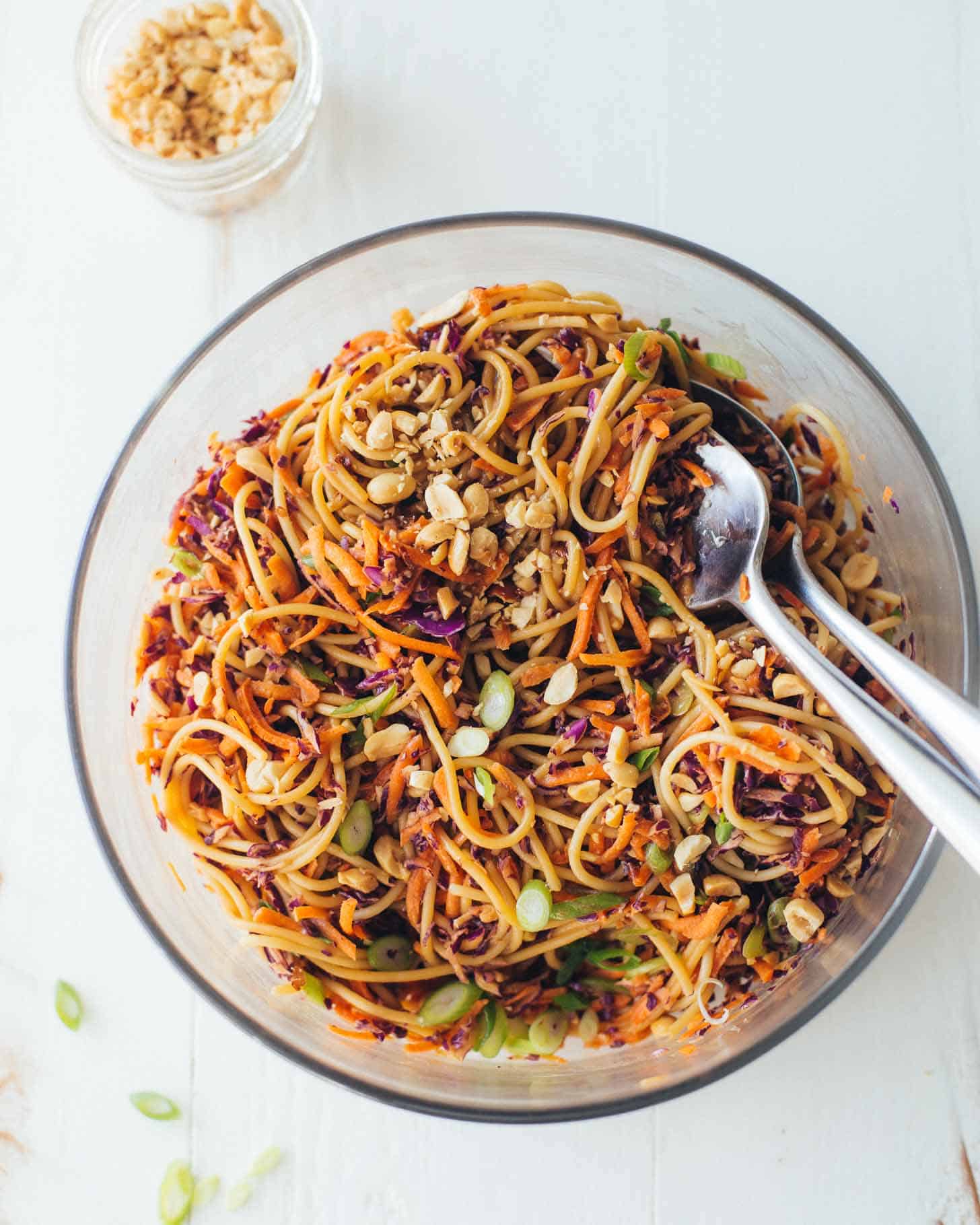 Sesame Noodle Salad in a clear bowl with salad spoons