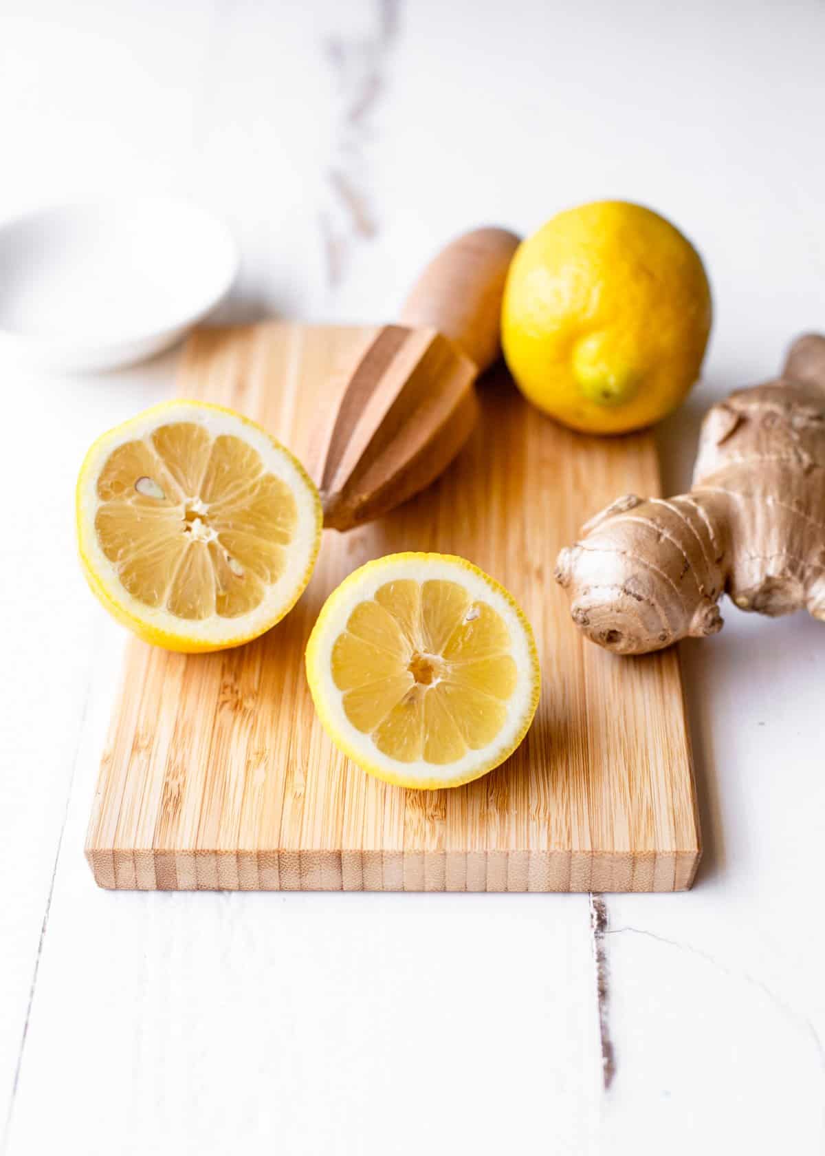 lemons and fresh ginger on a wooden cutting board