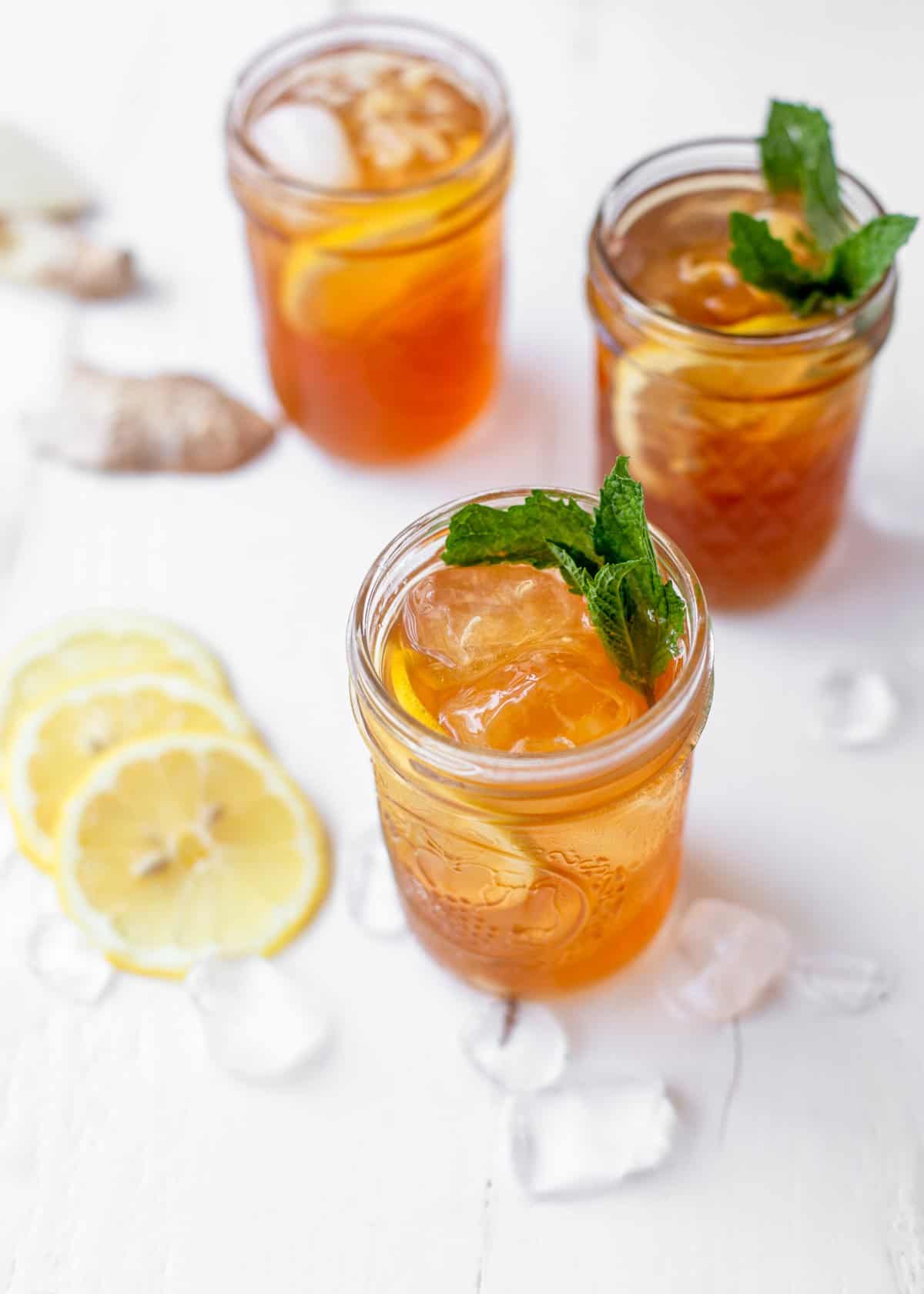 overhead image of bourbon sweet tea cocktail in a mason jar with ice and lemons