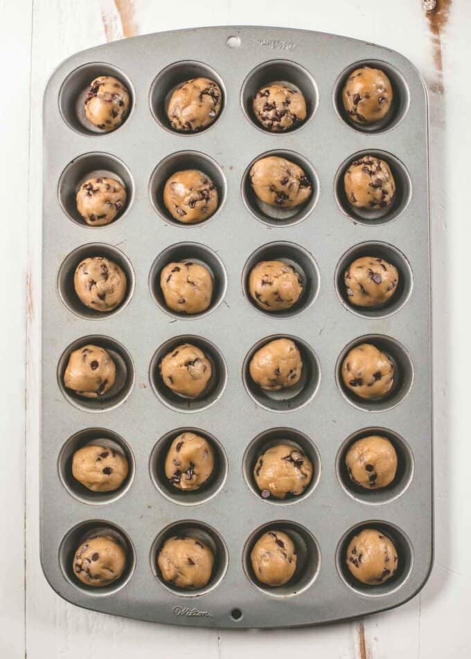 chocolate chip cookie dough in a muffin tin