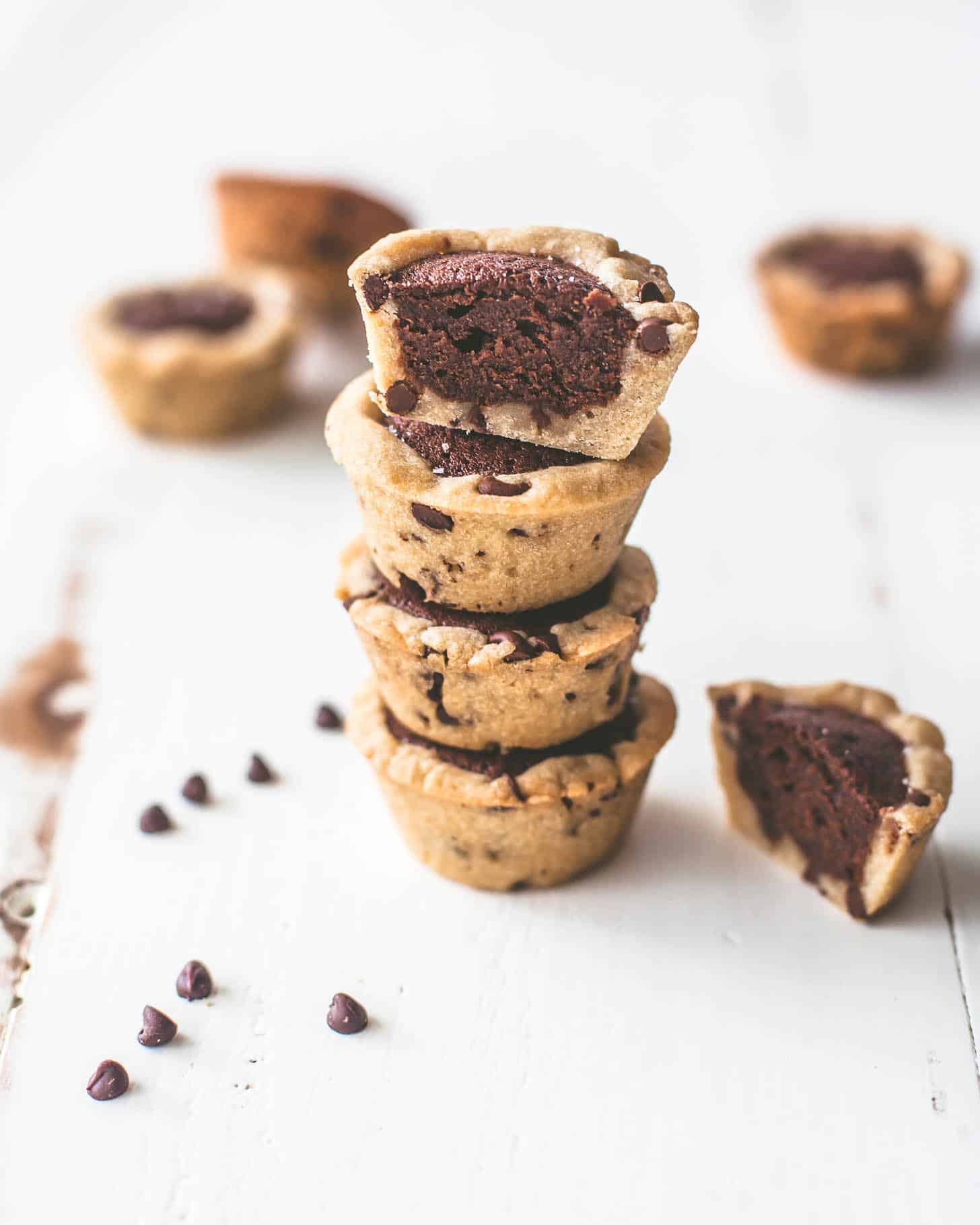 4 chocolate chip brownie tarts stacked on a white table