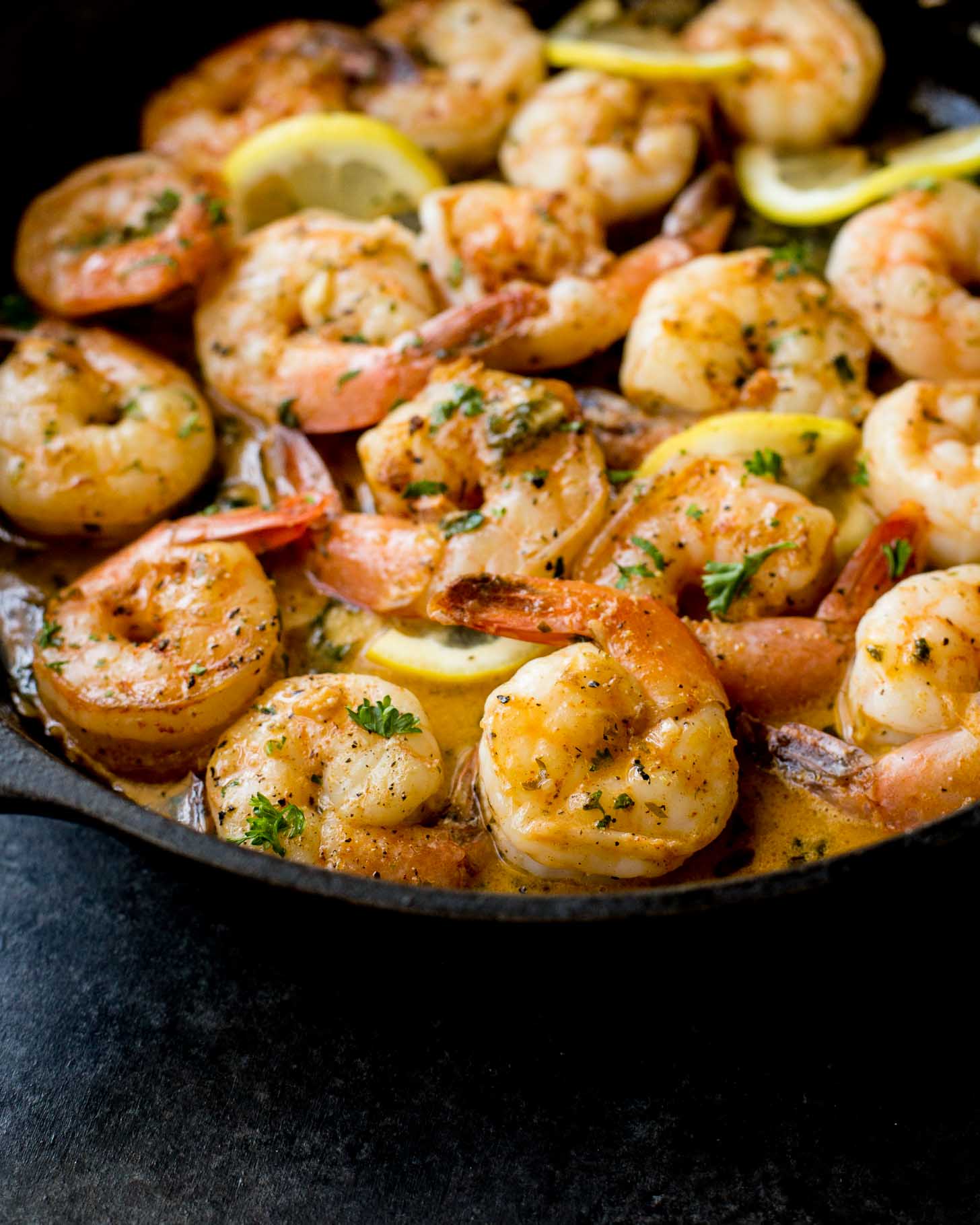 cooked shrimp and lemon slices in a cast iron skillet