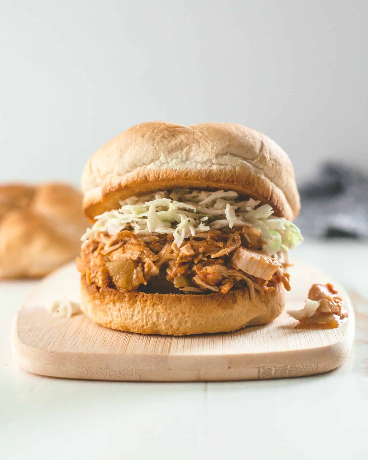 slow cooker hawaiian chicken on a bun with slaw