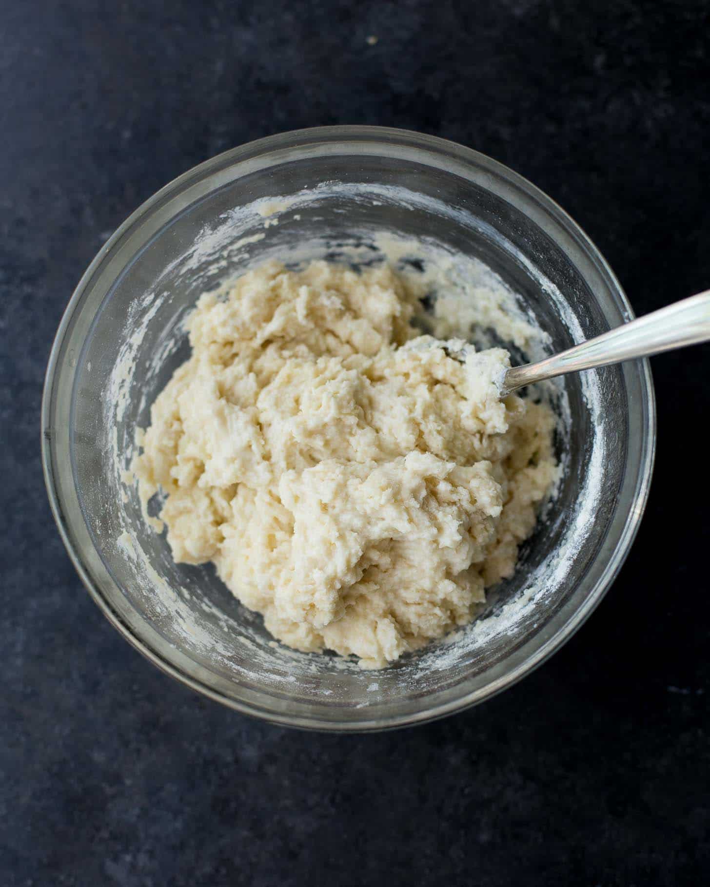 overhead image of drop biscuit dough after mixing in a clear glass bowl