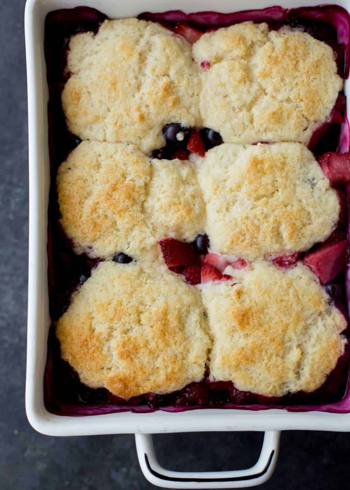 berry cobbler in a white baking dish