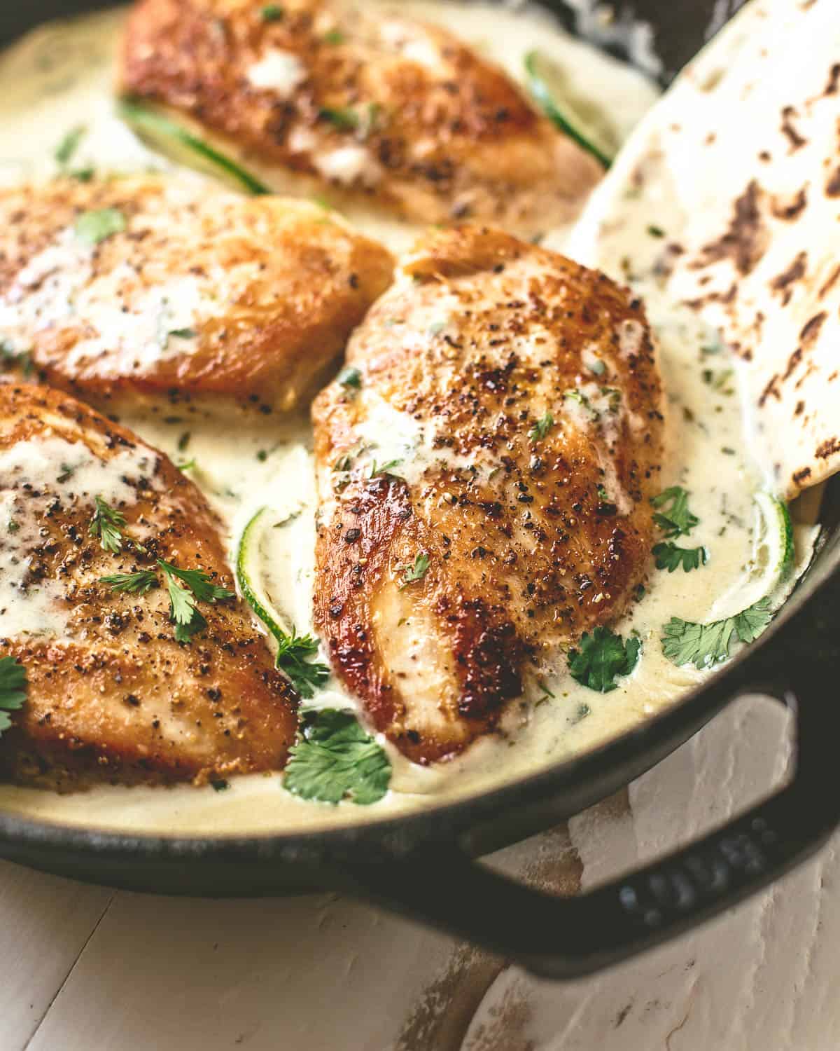 chicken in a skillet with creamy cilantro lime sauce