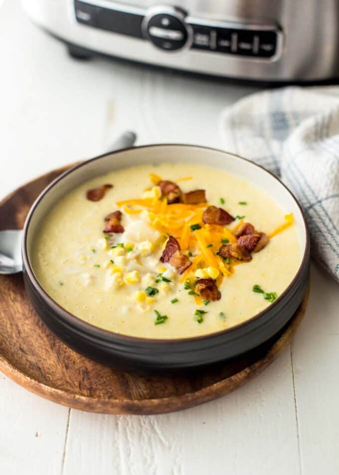 corn chowder topped with cheese and bacon in a black bowl