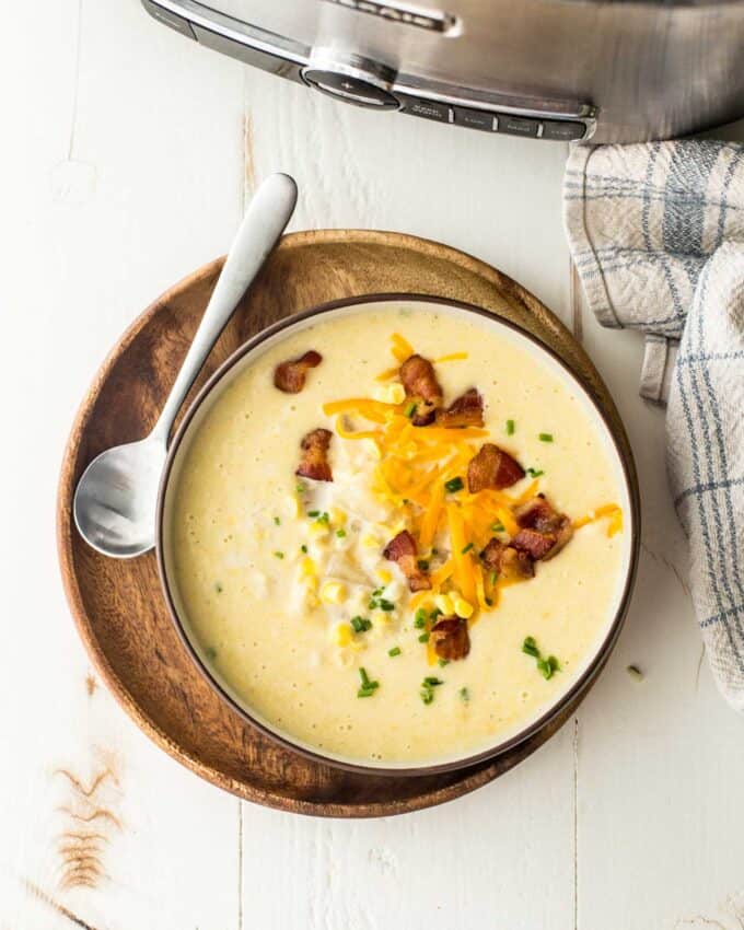 a bowl of chowder on a wooden try with a spoon