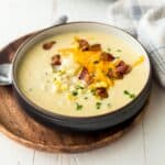 a bowl of corn chowder topped with cheese and bacon