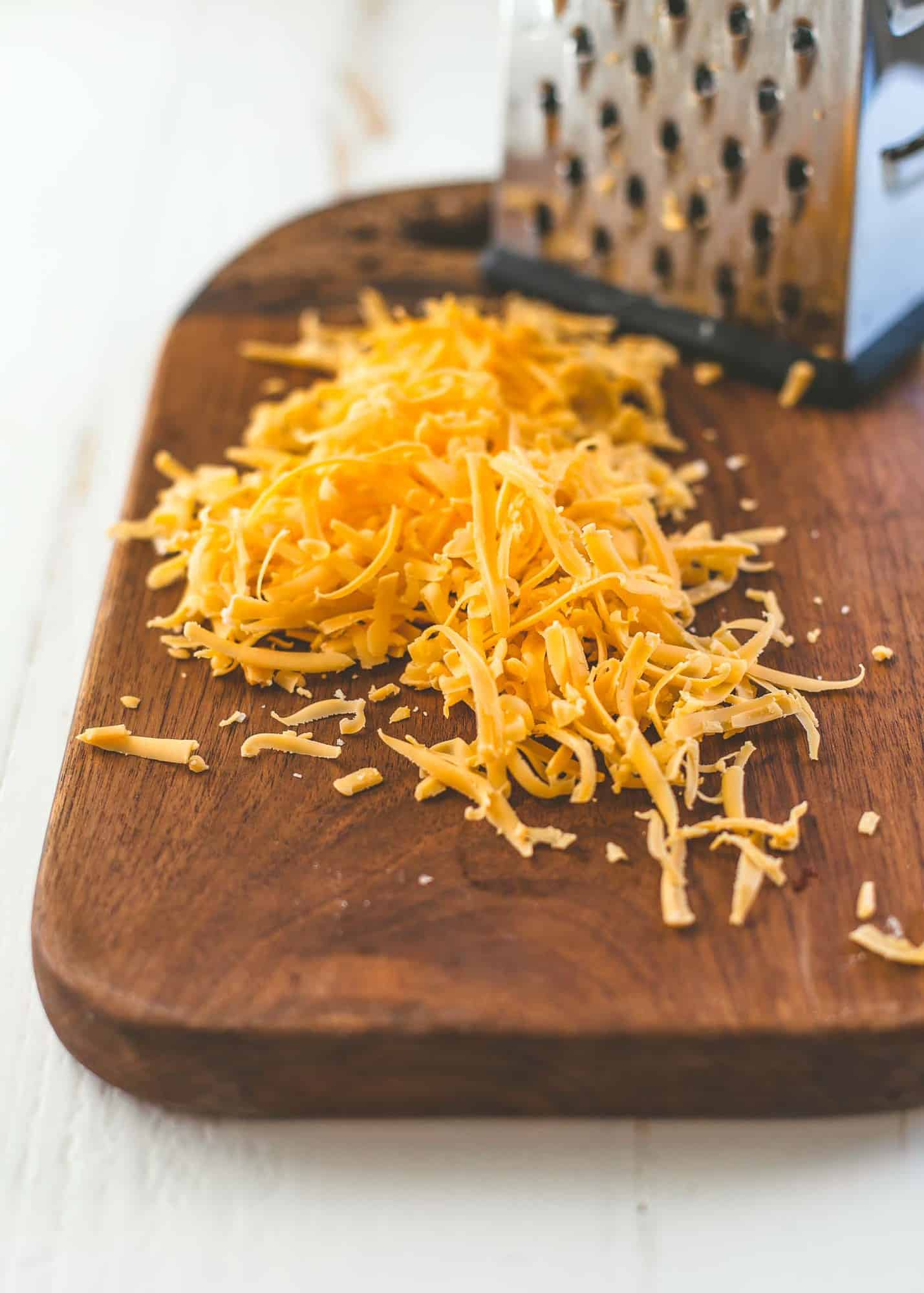 shredded cheddar on a wooden board