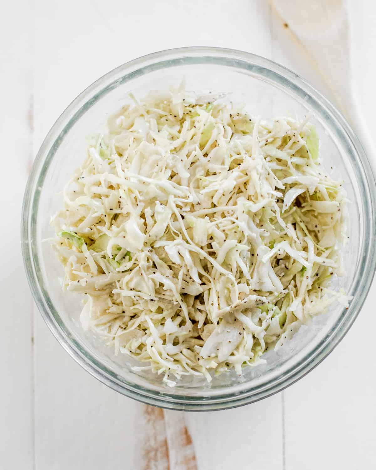 overhead image of coleslaw with green cabbage in a cream celery seed dressing