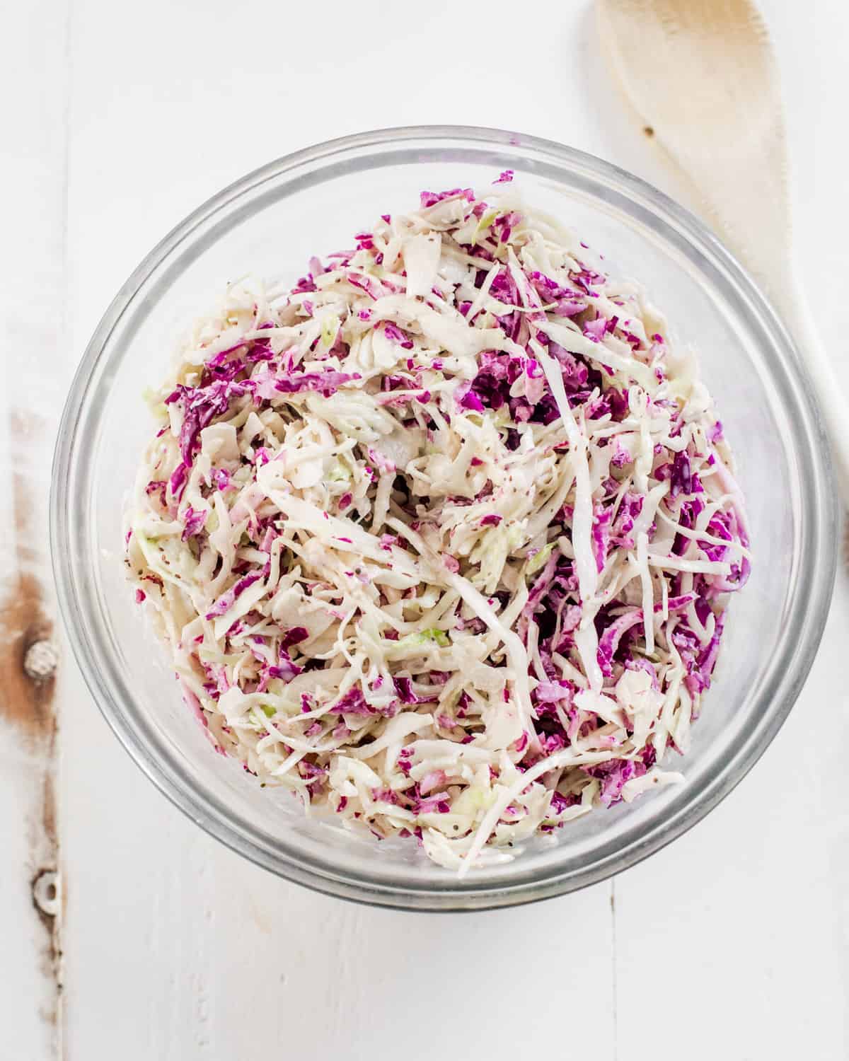 coleslaw in a glass bowl with red and green cabbage