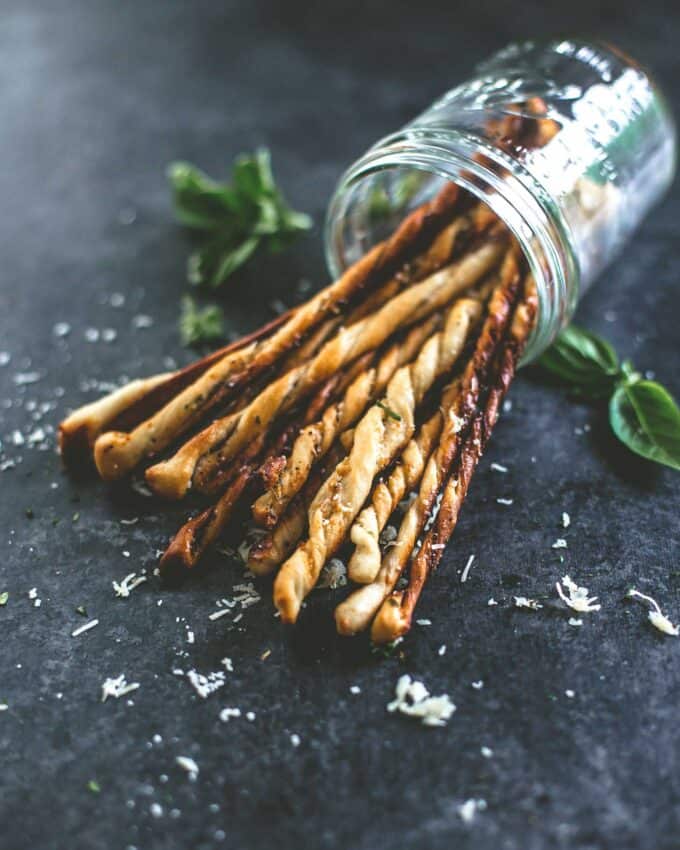 breadsticks falling out of an overturned glass jar