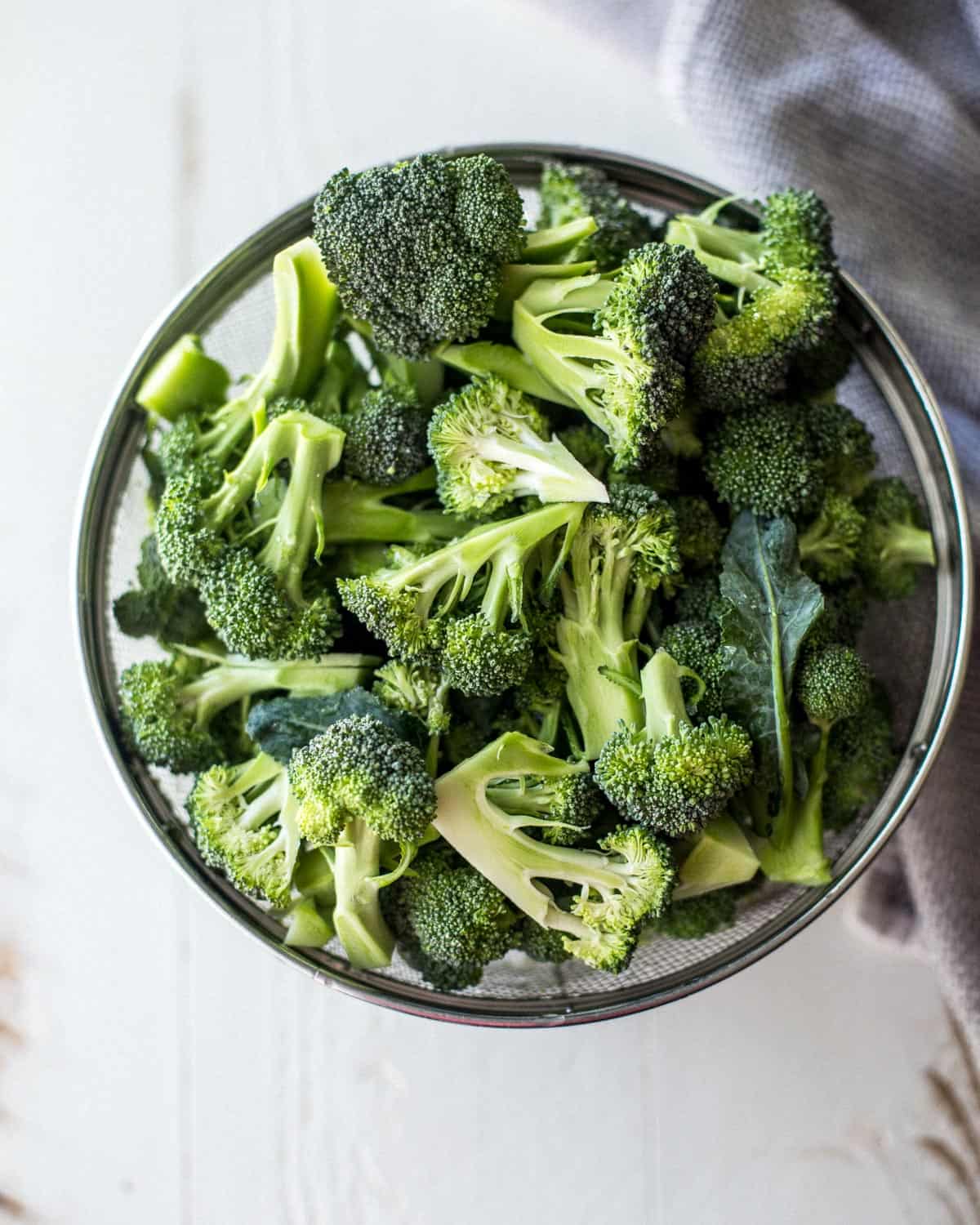 overhead image of raw broccoli in a clear bowl