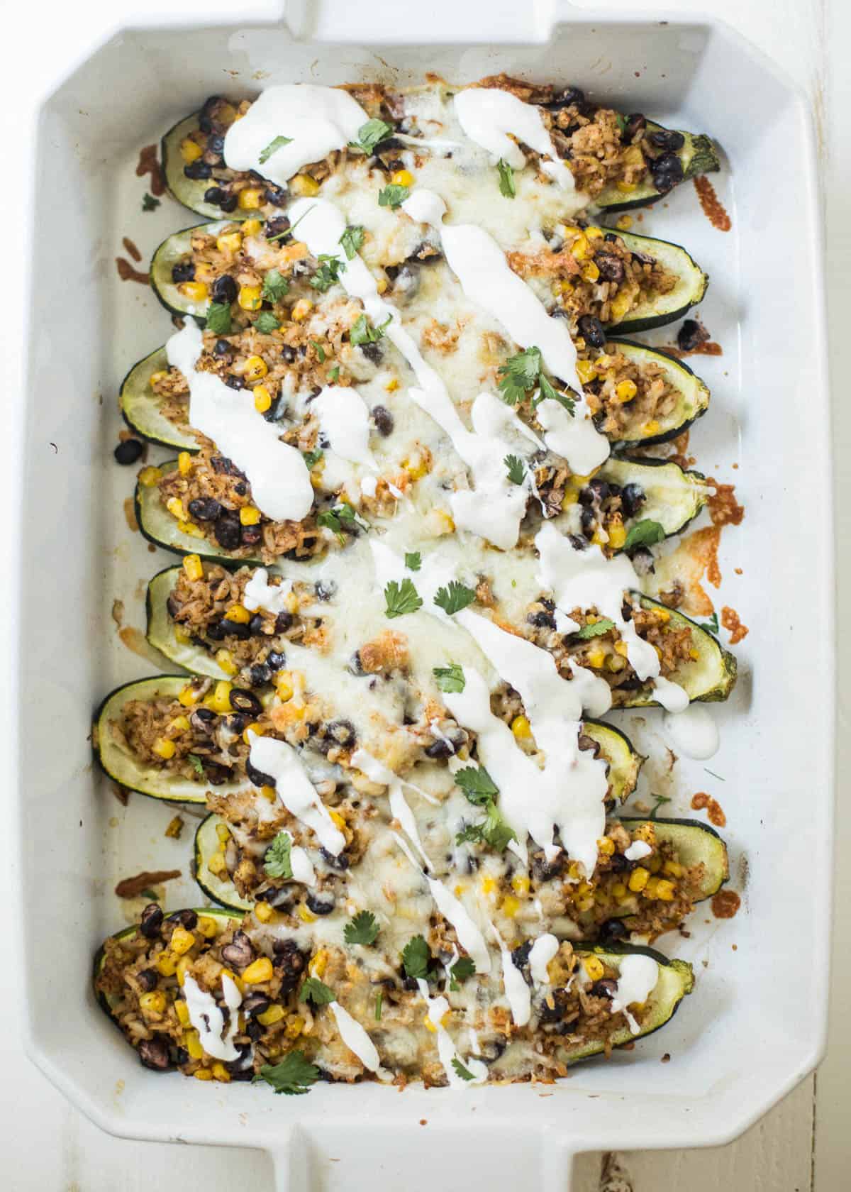 stuffed zucchini boats in a white dish