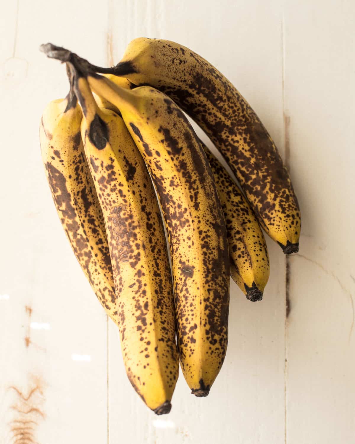 overhead image of ripe bananas on a white countertop