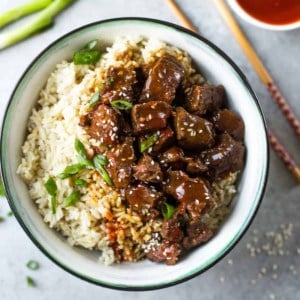 korean beef over rice in a blue and white bowl