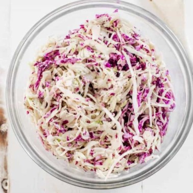 coleslaw in a glass bowl with red and green cabbage