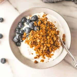 granola with yogurt and berries in a bowl with a spoon