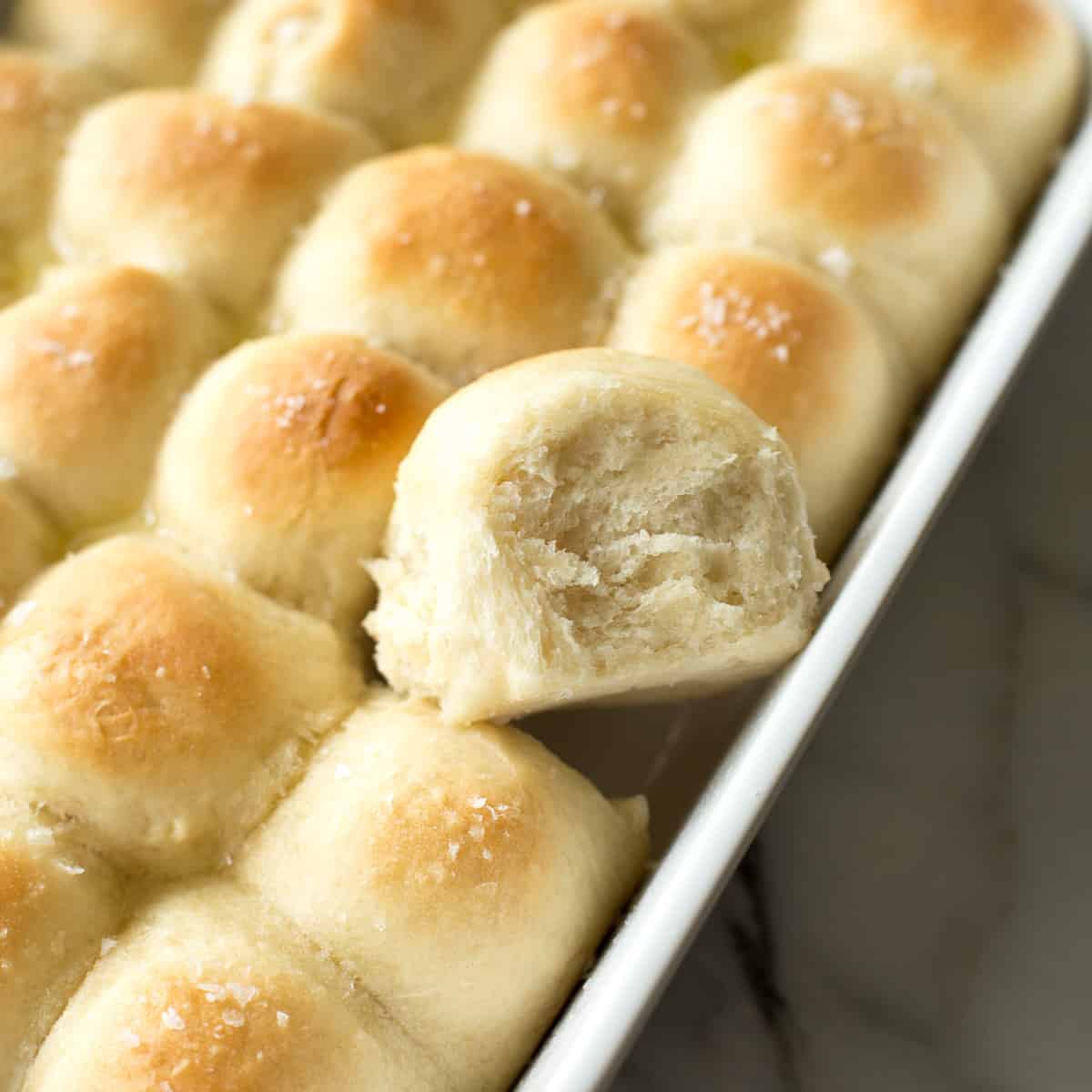 buttery dinner rolls in a rectangular white baking dish