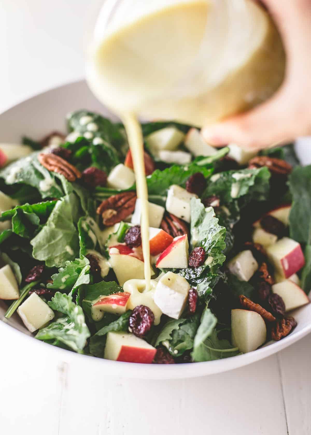 pouring vinaigrette over salad