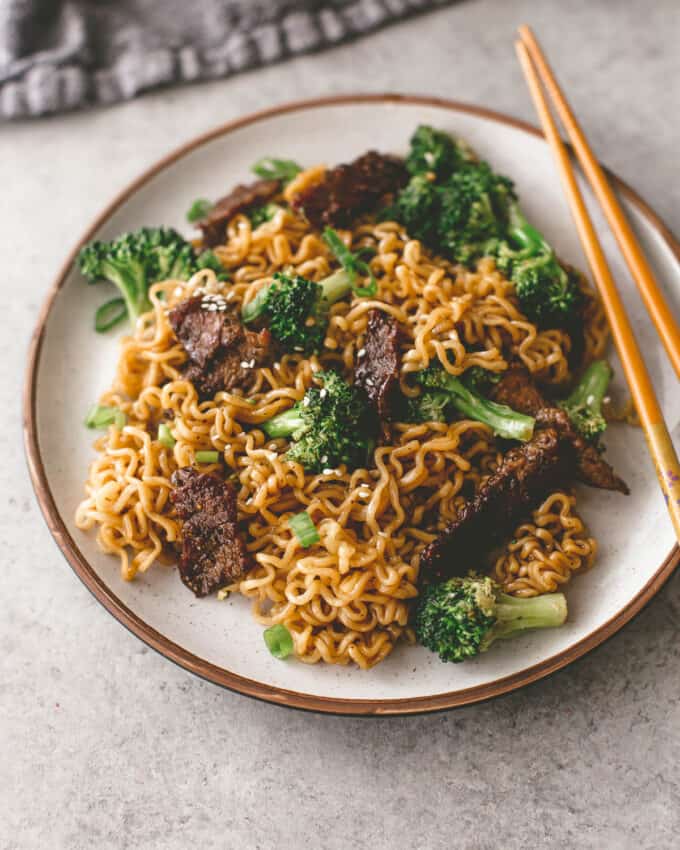 beef and broccoli stir fry on a plate with chopsticks