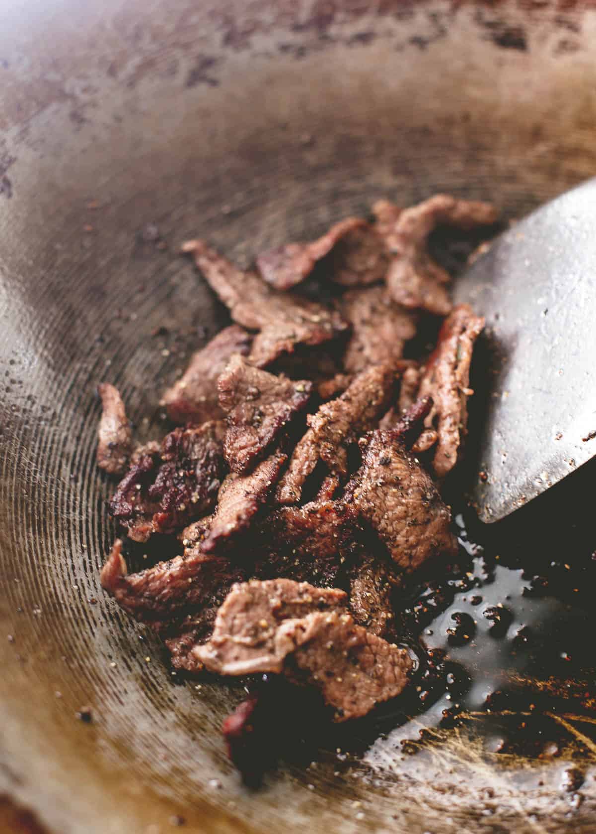 cooking steak strips in a wok