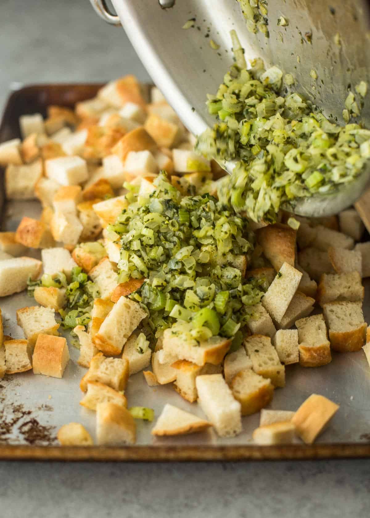 adding vegetables to bread cubes