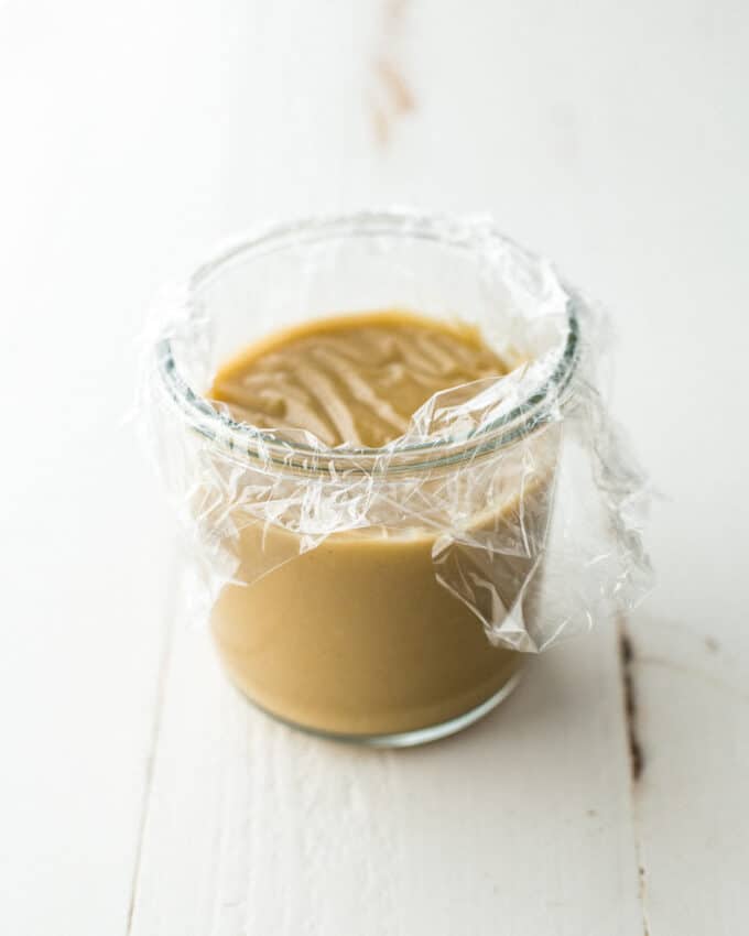 turkey gravy in a clear jar covered with plastic wrap
