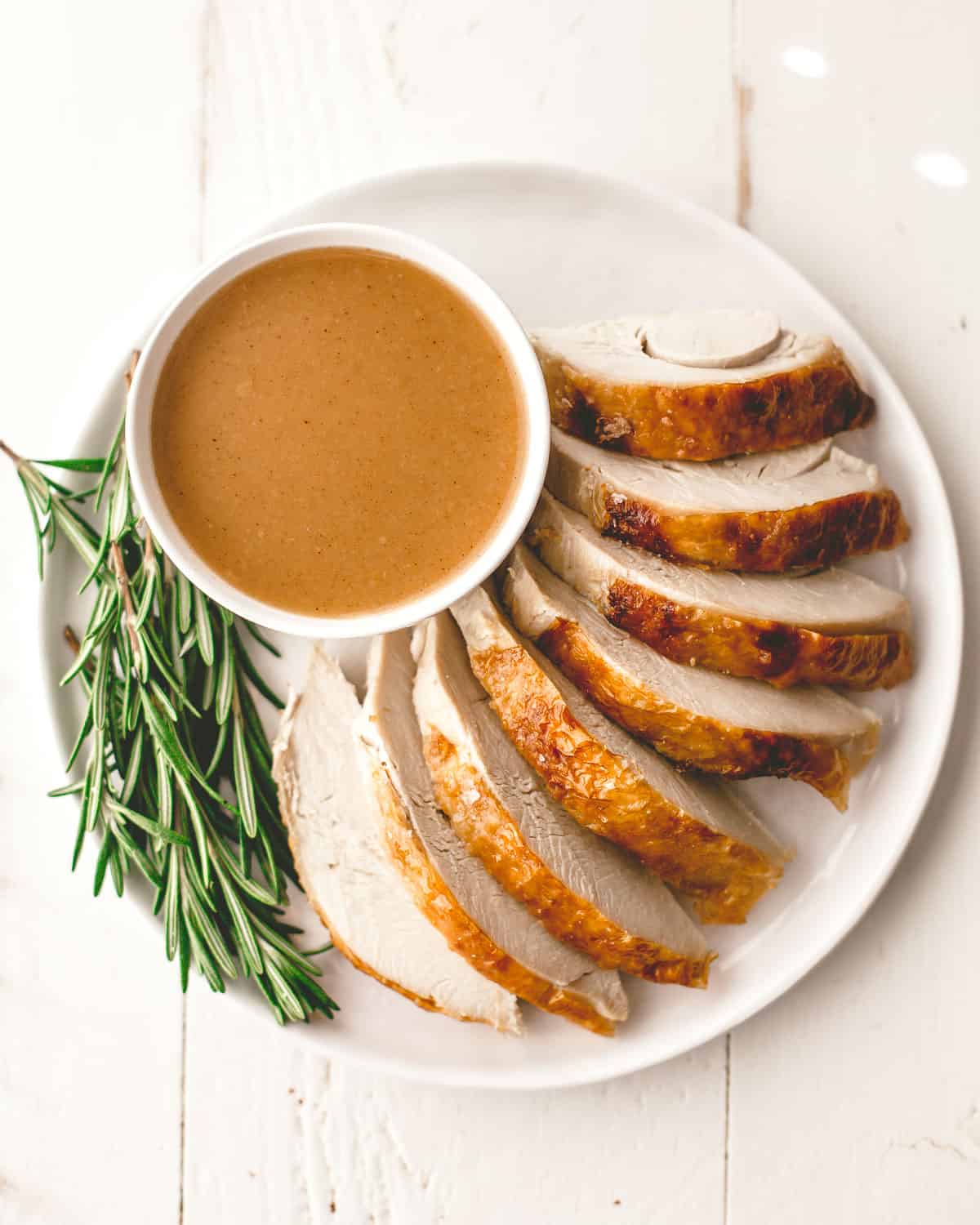 sliced turkey and gravy on a white plate