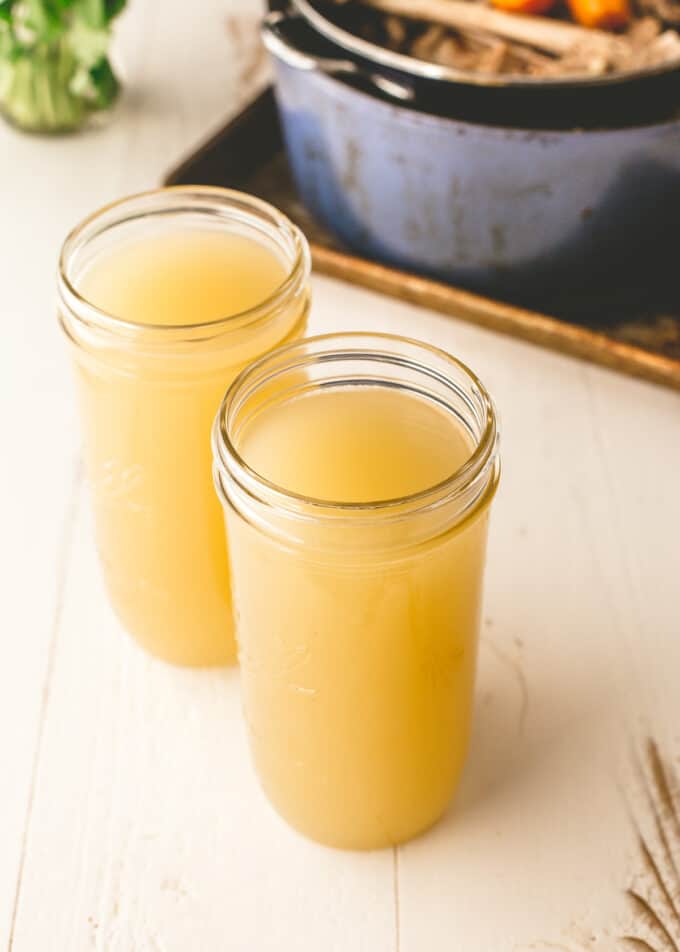 turkey stock in glass jars on a white table