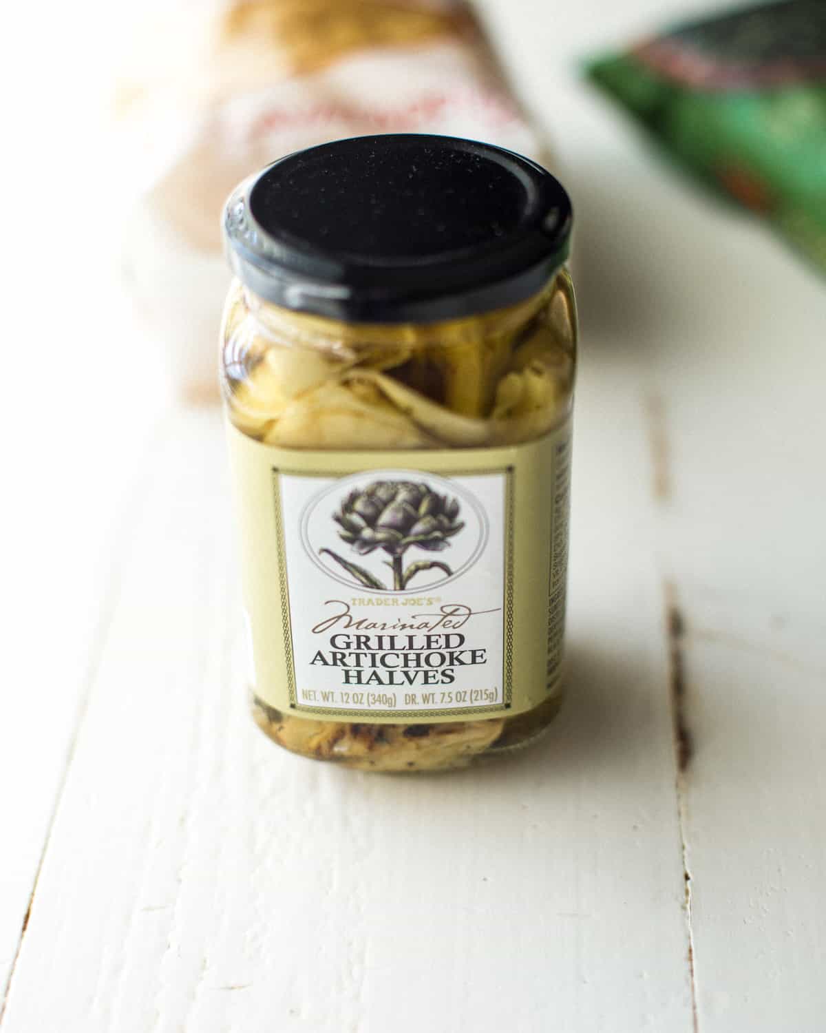 a jar of artichoke hearts on a white table