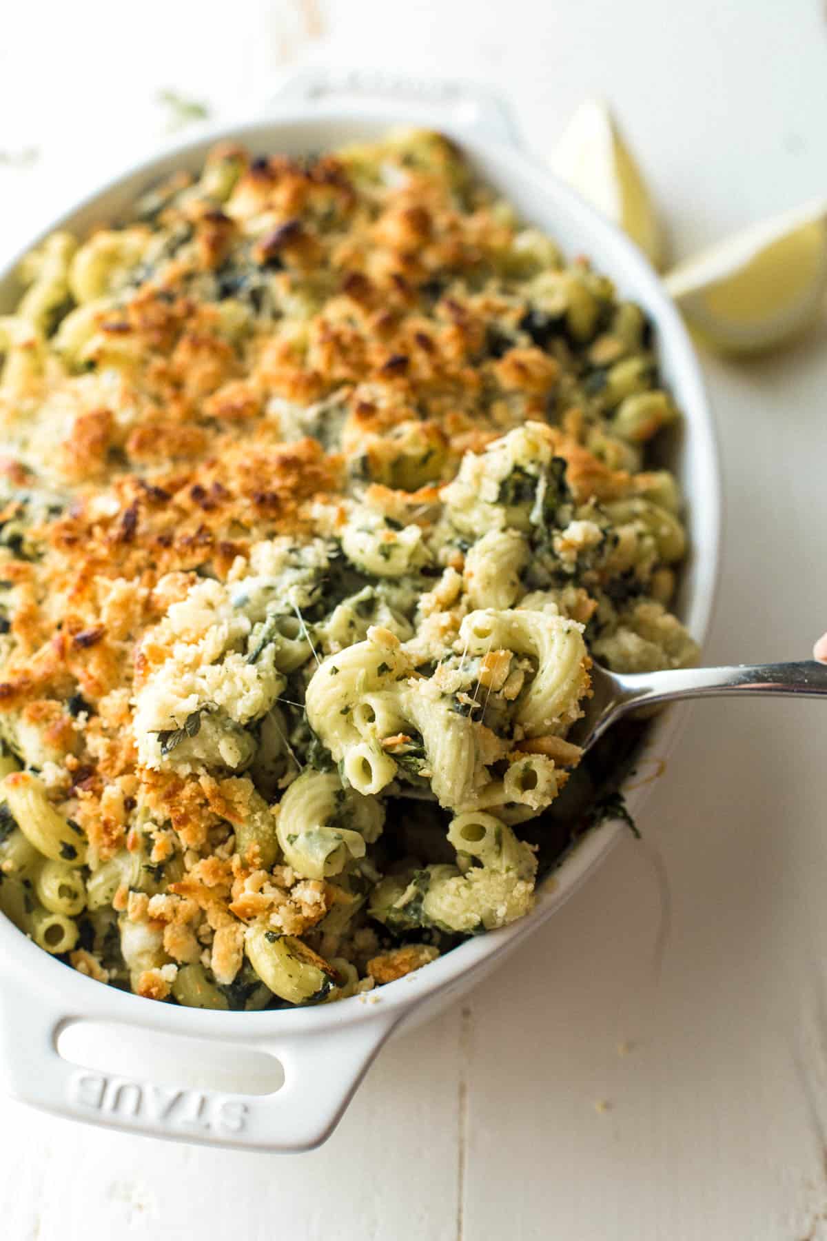 spinach and artichoke baked pasta in a white baking dish