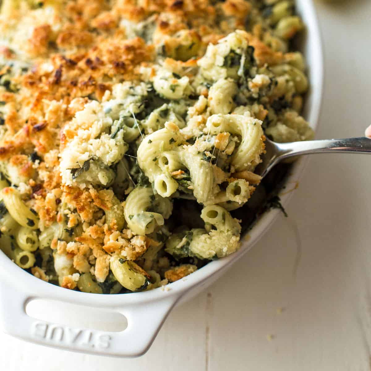 spinach and artichoke baked pasta in a white baking dish
