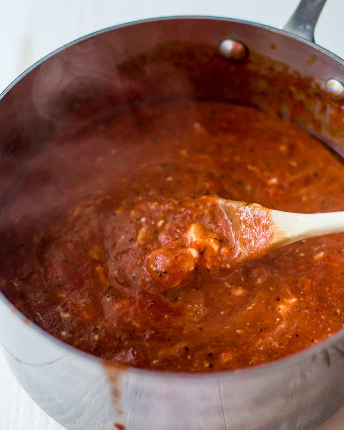 stirring tomato sauce in a saucepan