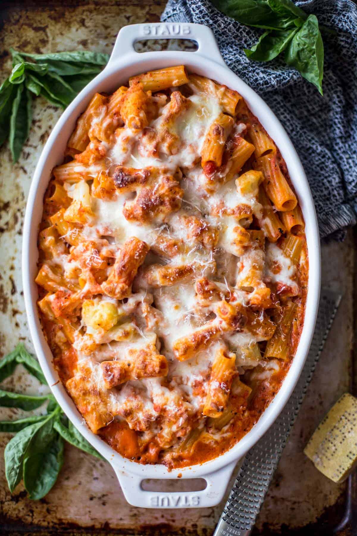 overhead image of cauliflower baked ziti in a white oval baking dish