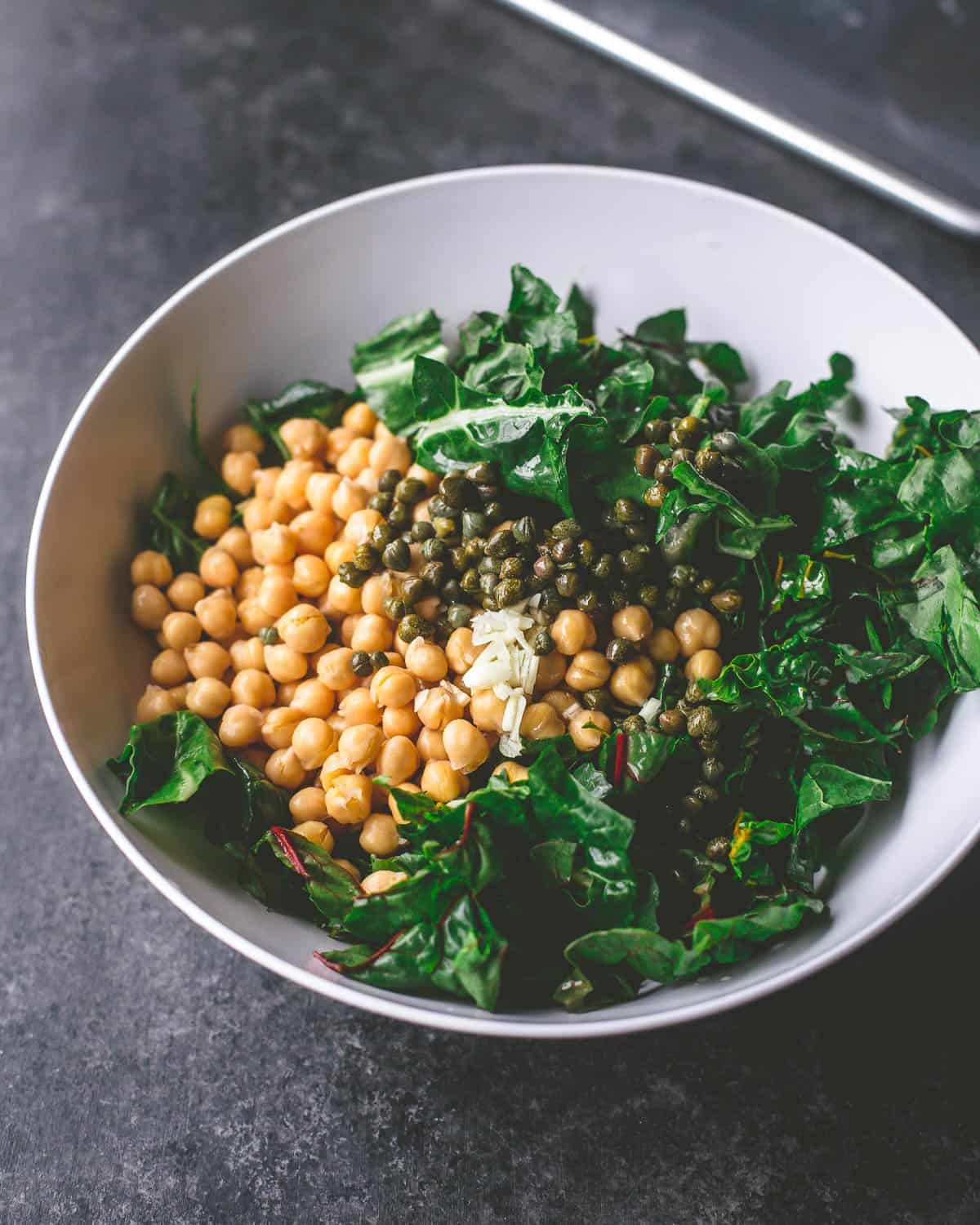 greens and chickpeas in a white bowl